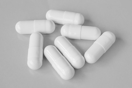 White pills on grey background.の写真素材