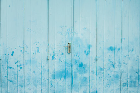 The vintage folding metal door with light blue painted and hand print stainの写真素材