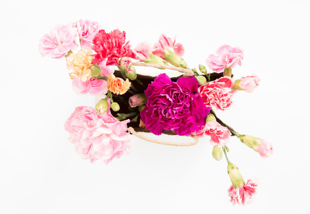Colorful carnations flowers in paper bag on white background.の写真素材