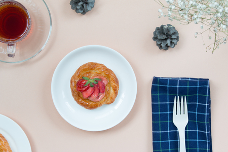Danish strawberry and a cup of tea on soft brown background.の写真素材