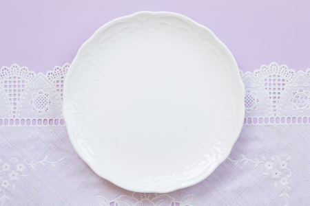 Blank white plate on blue and lace pattern background.の写真素材