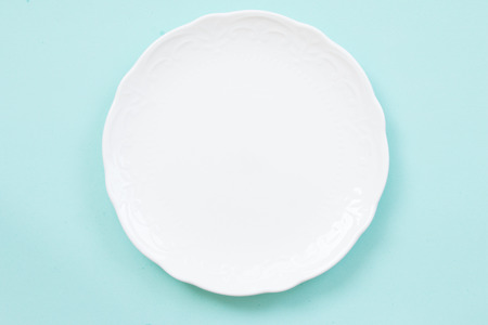 Blank white plate on blue background.