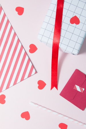 Red pattern paper and red ribbon on pink backgroundの写真素材