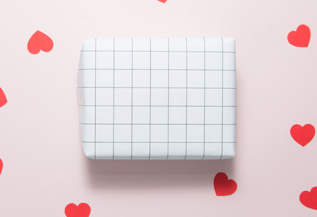 Top view of gift box and red hearts on pink background.の写真素材