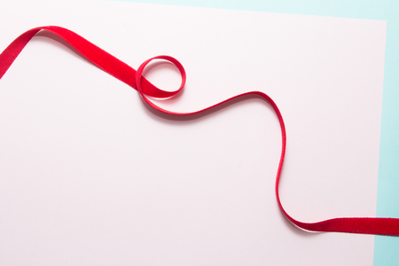 Red ribbon texture on pink paper backgroundの写真素材