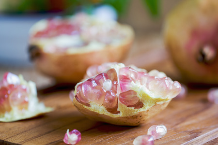 Fresh whole and halve pomegranates on chopping board