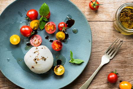 Mozzarella with Cherry Tomatoes salad on a wooden boardの写真素材