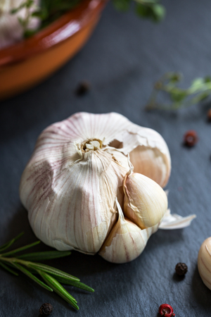 Garlic with sprig of Rosemary and Thyme in a clay dishの写真素材