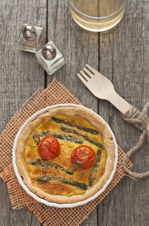 Quiche with asparagus and tomatoes with cup of wineの写真素材