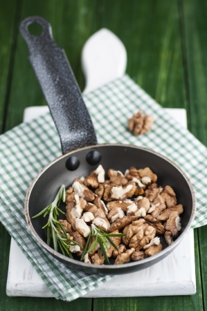 Roasting walnuts with rosemary in a panの写真素材