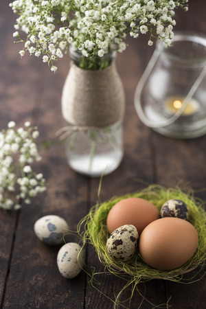 Raw eggs in a basket with flowersの写真素材