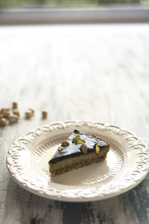 A slice of chocolate and pistachio vegan cakeの写真素材
