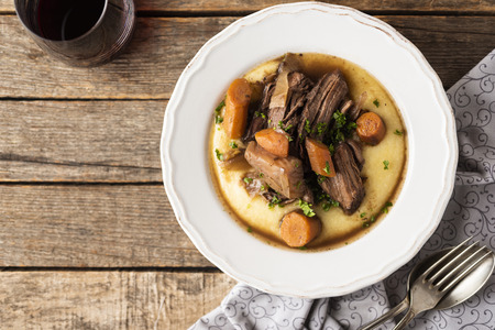Wild boar with polenta with a cup of red wineの写真素材