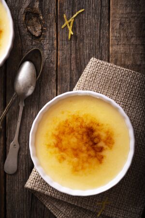 Catalan cream with spoons on old  wood tableの写真素材