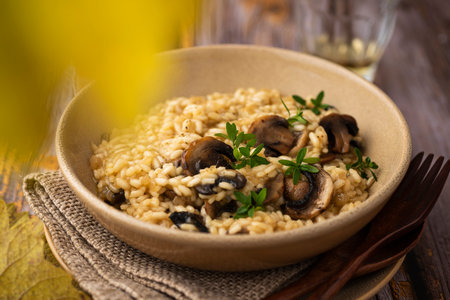 Mushroom risotto with thyme and a glass of wineの写真素材