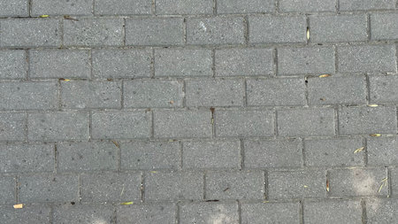 Gray abstract pattern background of cobblestone pavement top view.