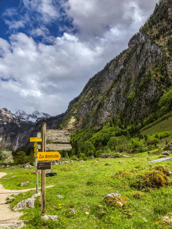 Signpost in a mountain valley. The valley is surrounded by green hills and mountains.の写真素材