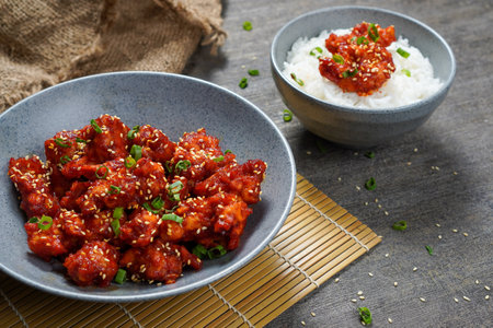 Yangnyeom Tongdak (Korean Spicy Fried Chicken)
Sweet and Spicy Chicken in spicy sauce with rice on wooden background.の写真素材