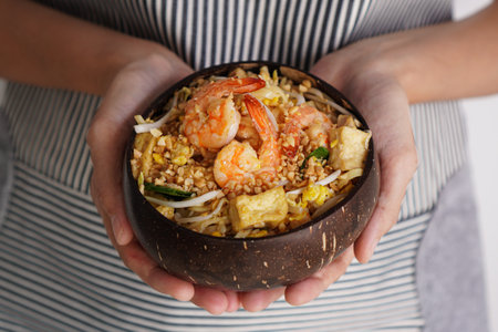 Woman holding a bowl of Pad Thai Shrimp Peanut Noodleの写真素材