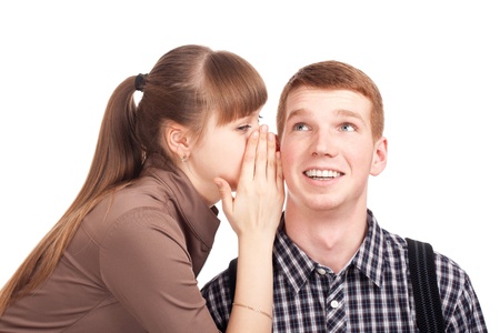 Young woman telling a secret to a manの写真素材