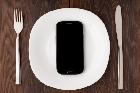 Mobile phone on a white plateの写真素材