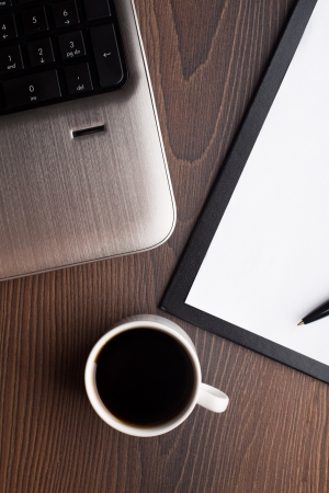 Laptop with fresh cup of coffee on a tableの写真素材