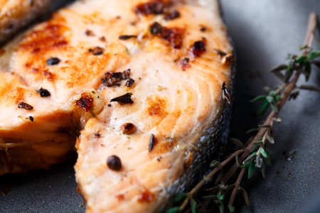 Pink salmon steak in frying pan with pepper and thymeの写真素材