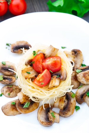 Pasta with fried mushrooms and cherry tomatoの写真素材