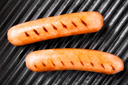 Delicious sausages on a black grill panの写真素材