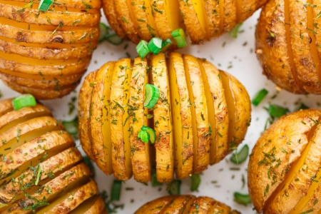 Accordion baked potatoes on a white plateの写真素材