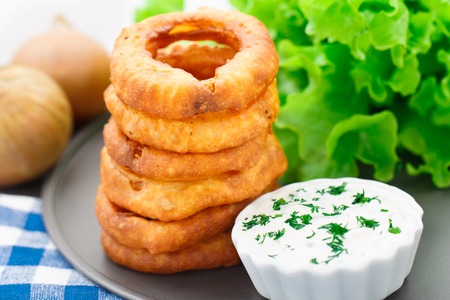 Delicious onion rings with sour cream sauceの写真素材