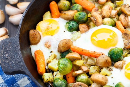 Baked eggs with vegetables, mushrooms and herbsの写真素材