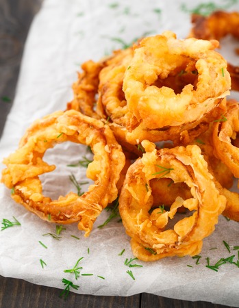 Homemade crunchy fried onion rings on a parchmentの写真素材