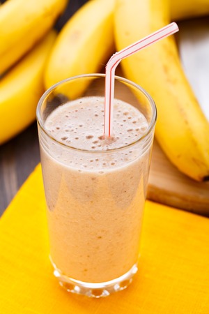 Glass of delicious banana smoothie on a tableの写真素材