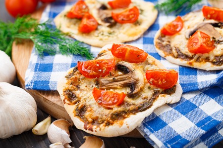 Vegetarian mini pizza with cherry tomatoes and mushroomsの写真素材