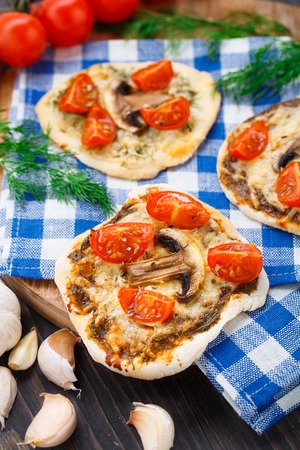 Vegetarian mini pizza with cherry tomatoes and mushroomsの写真素材