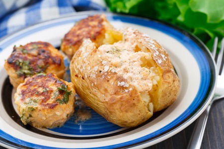 Jacket potato with meatballs on a plateの写真素材
