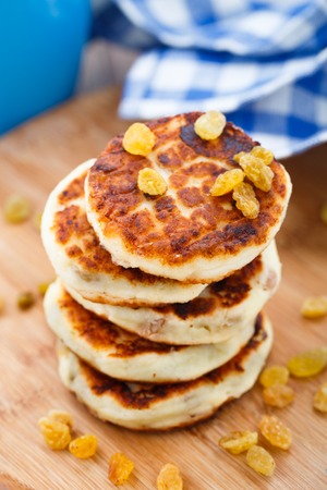Cheese pancakes with raisins on a wooden boardの写真素材