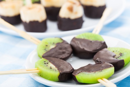 Fresh fruits with chocolate on a stickの写真素材