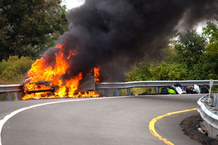 Car on fire with passengersの写真素材