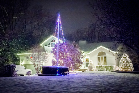 Decorated house for Christmas at night covered in snowの写真素材