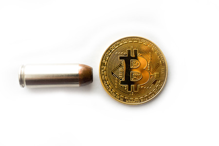 Bitcoin with bullet on white background close upの写真素材