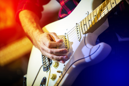 Artist playing electric guitar on the stage solo