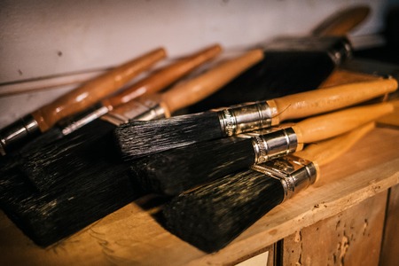 Several big black paint brushes on the shelfの写真素材