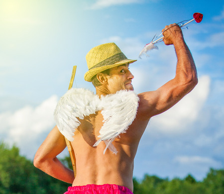White guy with wings on his back. He displays bow with arrow. Cupid on Valentine's dayの写真素材