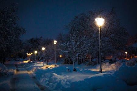 Heavy winter snow after storm at night with street lightsの写真素材