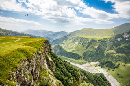 Scenic view at Gudauri View Point monument with paragliding parachutes at summer day