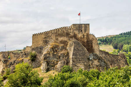 Close up view of Surami Fortress in Georgia with flag in summer day
