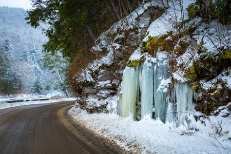 Icy road pavement with frozen ice along the side