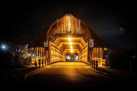 Photo of Bavarian Inn old wooden covered bridge in Frankenmuth Michigan illuminated at night with warm lights and Bavarian charm.の写真素材